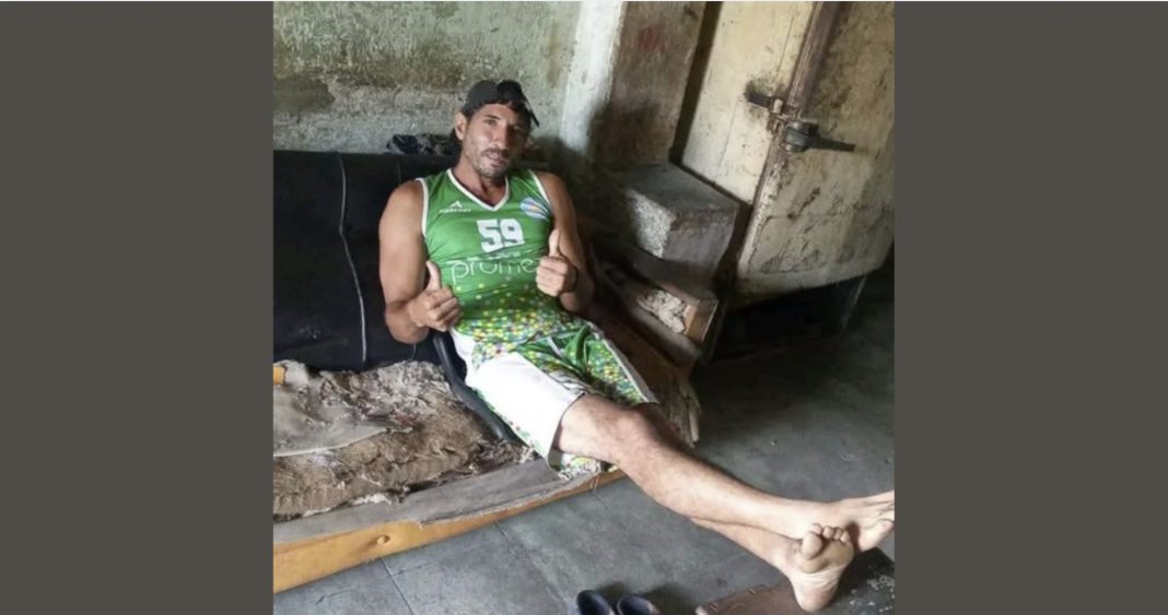 Joven cubano de 35 años de Manicaragua, Villa Clara, sentado en su deteriorado hogar junto a un refrigerador oxidado de los años 60 y un sofá destrozado, en la foto publicada por la presidenta del Poder Popular local para celebrar su adhesión a la campaña 