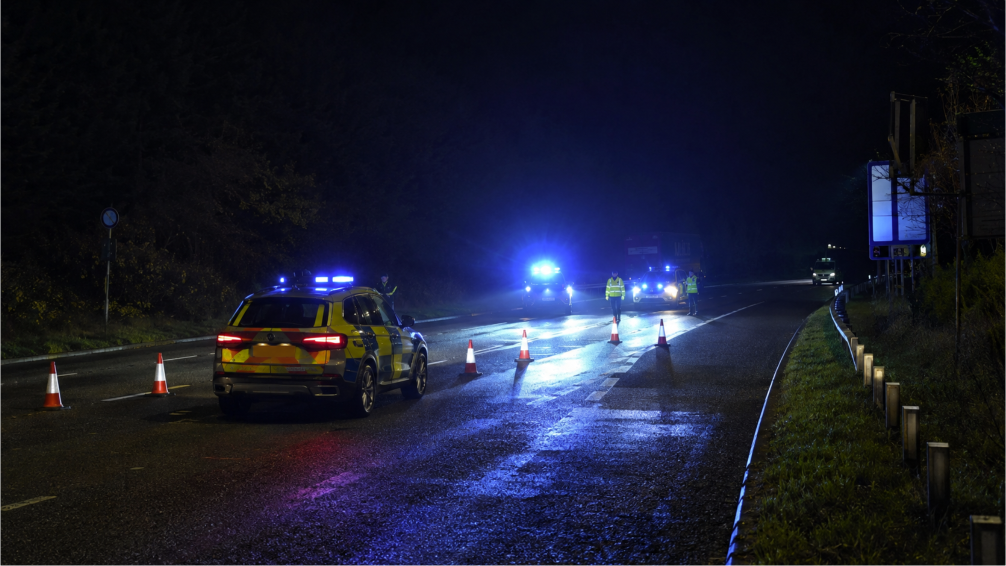 Tramo de una carretera principal cerrada al tráfico con presencia policial de noche en el sur de Gales, cerca de Carmarthen