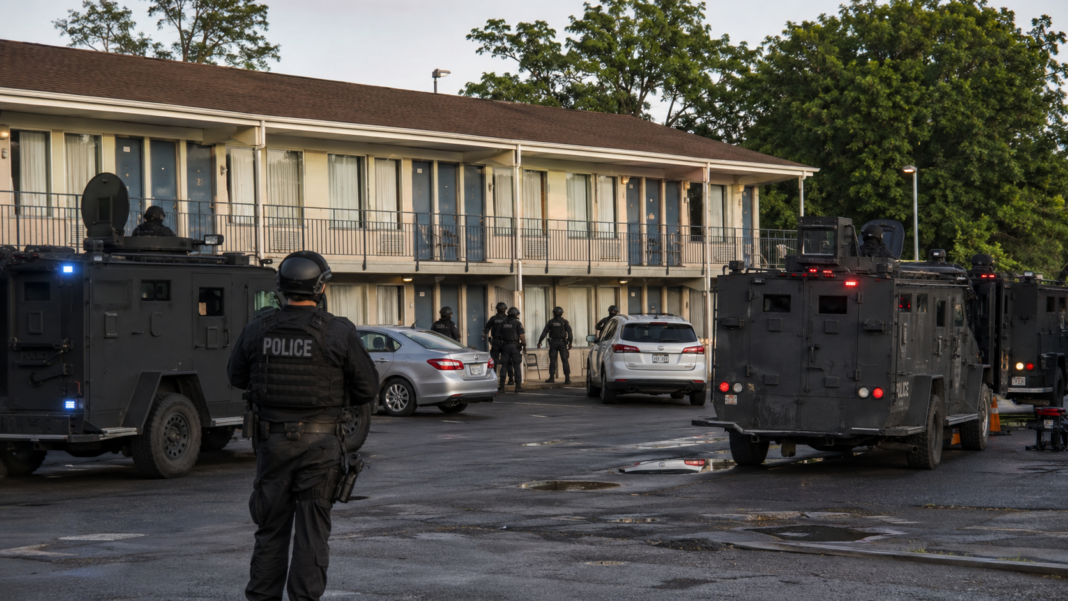 Vehículos de un equipo SWAT estacionados frente a un motel durante un operativo policial