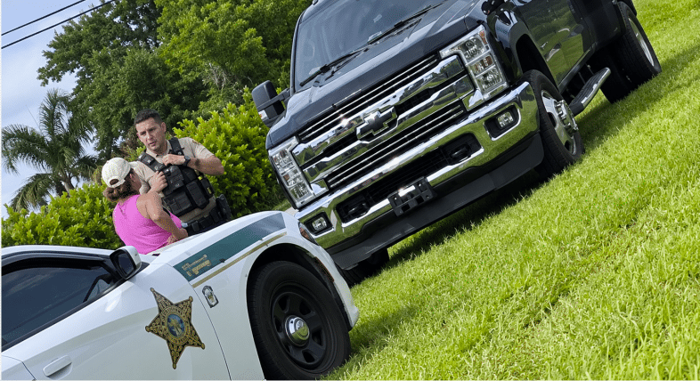 Hombre a caballo en una carretera de Homestead mientras una mujer le reclama desde su camioneta.